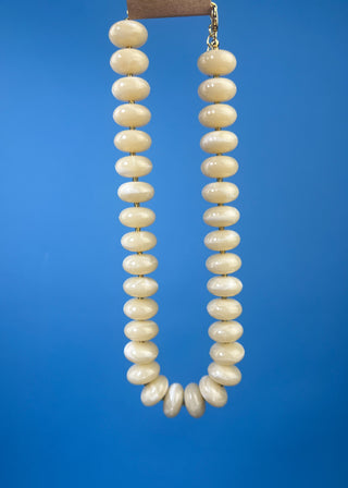Chunky marbled resin bead statement necklace with oversized cream beads, gold-tone spacer accents, adjustable clasp closure, and lightweight design, available in multiple colors.