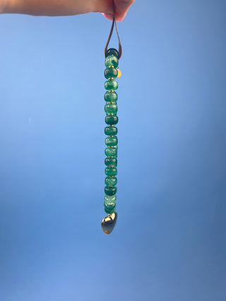 Green marbled resin bead necklace with polished gold heart pendant, gold-tone spacer accents, adjustable cord closure, and lightweight statement design available in multiple colors.