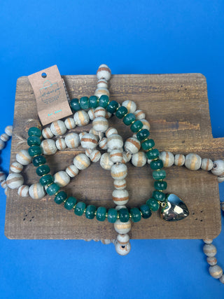 Green marbled resin bead necklace with polished gold heart pendant, gold-tone spacer accents, adjustable cord closure, and lightweight statement design available in multiple colors.