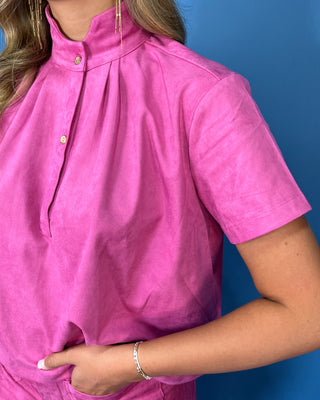 Woman modeling a hot pink mock neck short sleeve top with a matching mini skort and front pockets.