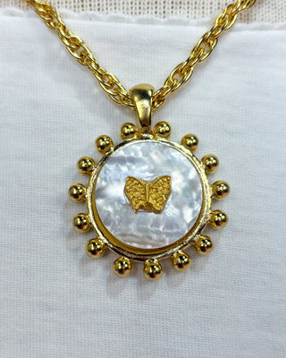 Gold necklace with a butterfly pendant on a white background