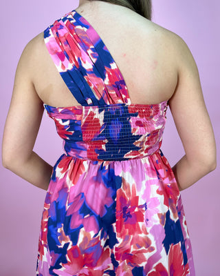 Colorful floral dress on a person against a pink background