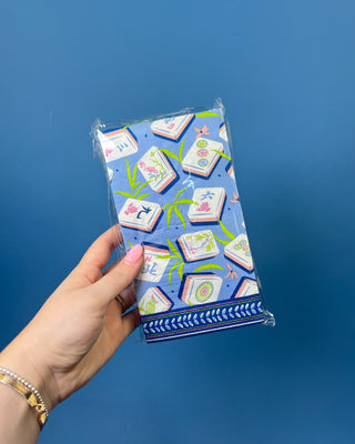 Package of Mahjong Guest Napkins featuring colorful Mahjong tile illustrations with bamboo leaves on a soft blue background. Premium 3-ply paper guest towels for entertaining and game nights.