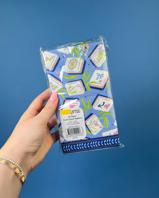 Package of Mahjong Guest Napkins featuring colorful Mahjong tile illustrations with bamboo leaves on a soft blue background. Premium 3-ply paper guest towels for entertaining and game nights.