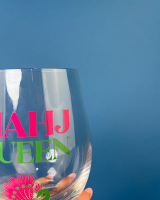 Mahj Queen stemless wine glass with vibrant pink and green lettering and a colorful peacock design on clear glass, perfect for Mahjong game nights and entertaining.