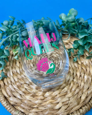 Mahj Queen stemless wine glass with vibrant pink and green lettering and a colorful peacock design on clear glass, perfect for Mahjong game nights and entertaining.