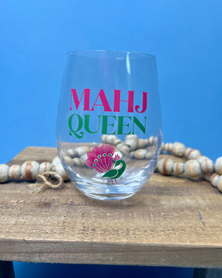Mahj Queen stemless wine glass with vibrant pink and green lettering and a colorful peacock design on clear glass, perfect for Mahjong game nights and entertaining.