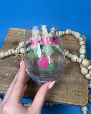 Mahj Queen stemless wine glass with vibrant pink and green lettering and a colorful peacock design on clear glass, perfect for Mahjong game nights and entertaining.