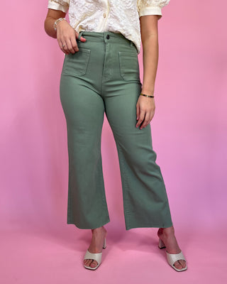 Person wearing green pants on a pink background