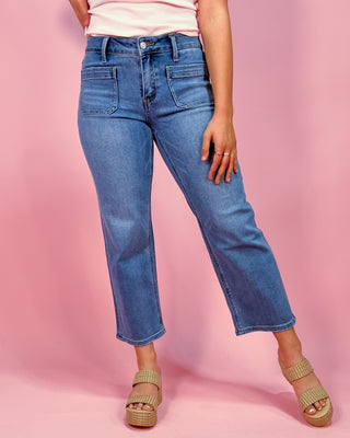 Person wearing blue jeans on a pink background