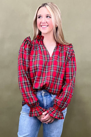 Woman wearing a red plaid blouse against a beige background