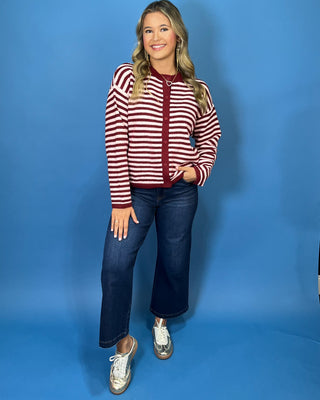 Burgundy and ivory striped button-front knit cardigan with long sleeves, contrast trim, and a relaxed fit.