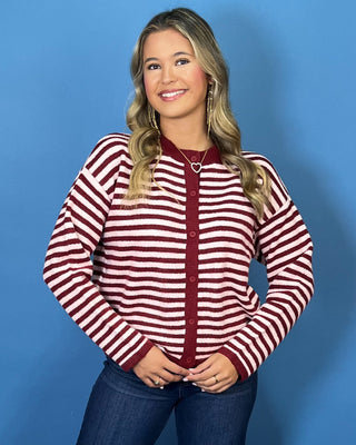 Burgundy and ivory striped button-front knit cardigan with long sleeves, contrast trim, and a relaxed fit.
