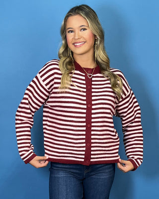Burgundy and ivory striped button-front knit cardigan with long sleeves, contrast trim, and a relaxed fit.