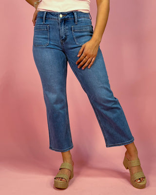 Person wearing blue jeans on a pink background
