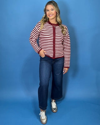 Burgundy and ivory striped button-front knit cardigan with long sleeves, contrast trim, and a relaxed fit.