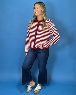 Burgundy and ivory striped button-front knit cardigan with long sleeves, contrast trim, and a relaxed fit.