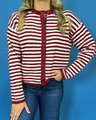 Burgundy and ivory striped button-front knit cardigan with long sleeves, contrast trim, and a relaxed fit.