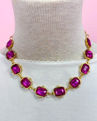 Necklace with pink gemstones on a mannequin against a pink background