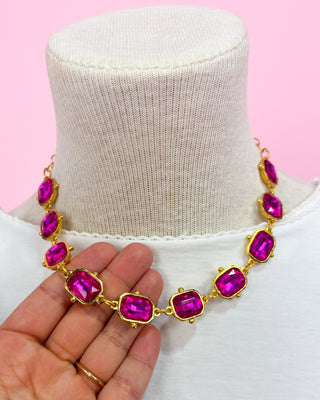 Necklace with pink gemstones on a mannequin against a pink background