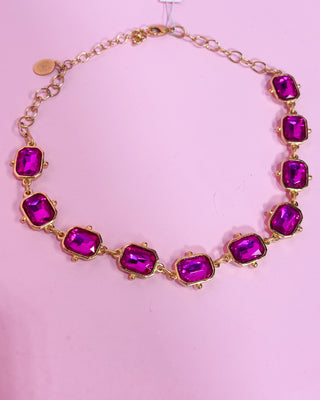 Necklace with purple gemstones on a pink background