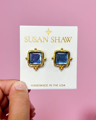 Gold and blue earrings on a Susan Shaw branded card against a pink background