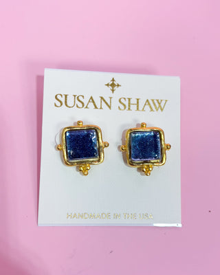 Gold and blue square earrings on a Susan Shaw branded card with a pink background