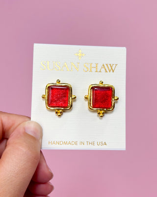 Red square earrings with gold accents on a Susan Shaw card against a pink background