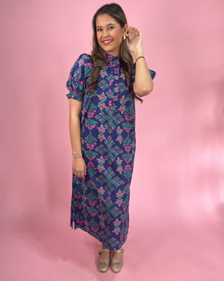 Woman wearing a floral dress against a pink background