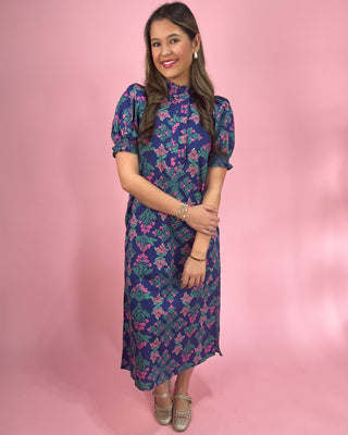 Woman wearing a floral dress against a pink background
