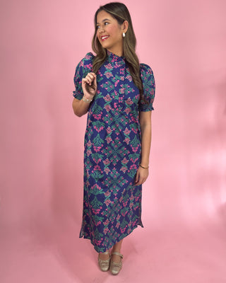 Woman wearing a floral dress against a pink background