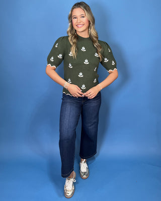 Forest green floral knit sweater top with puff sleeves, blue embroidered flowers, and scalloped contrast trim.