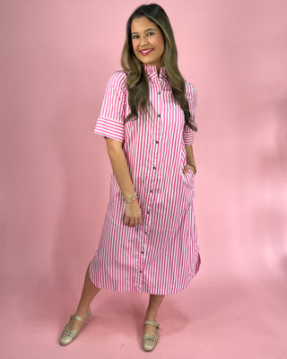 Woman wearing a pink and white striped dress against a pink background