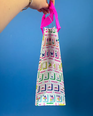 Mahjong Reusable Bag with colorful Mahjong tile print and bright pink handles, foldable reusable shopping tote for errands, gifts, and game nights.