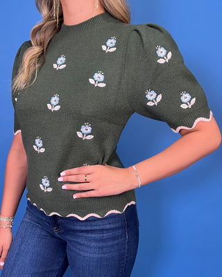 Forest green floral knit sweater top with puff sleeves, blue embroidered flowers, and scalloped contrast trim.