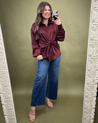 Beige sandal with a block heel being worn, on a light background