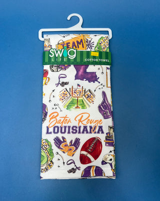 Swig Life Tailgates In Baton Rouge cotton kitchen towel featuring Baton Rouge football, stadium, helmets, footballs, and purple and gold game day illustrations.