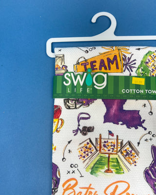 Swig Life Tailgates In Baton Rouge cotton kitchen towel featuring Baton Rouge football, stadium, helmets, footballs, and purple and gold game day illustrations.