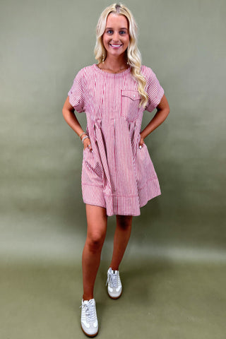 Woman wearing a pink checkered dress against a green background