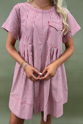 Person wearing a pink and white striped dress against a green background