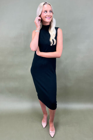Woman wearing a black dress against a plain background