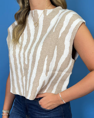 Ivory and beige zebra print sleeveless knit top with a high neckline and relaxed fit.