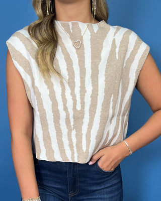 Ivory and beige zebra print sleeveless knit top with a high neckline and relaxed fit.