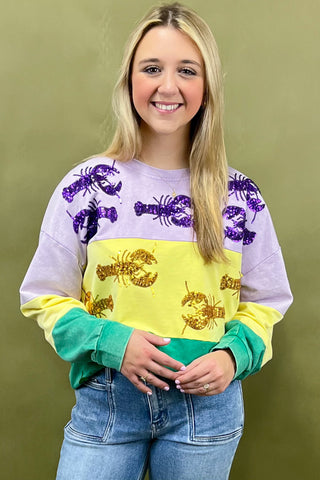 Person wearing a colorful sweater with lobster designs on a green background