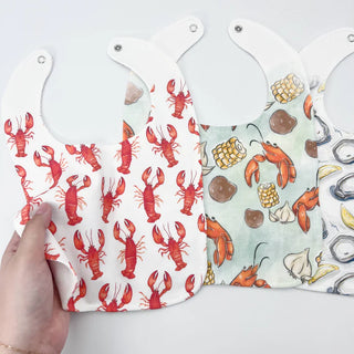Two bibs with lobster patterns on a white background