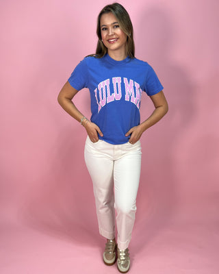 Person wearing a blue t-shirt with printed on it against a pink background