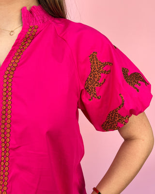 Pink top with leopard print designs on a pink background