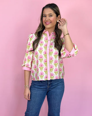 Woman wearing a floral blouse with a pink background