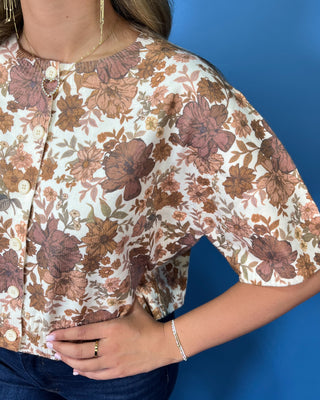 Ivory short sleeve button-front top with an allover brown, mocha, and tan floral print and relaxed fit.