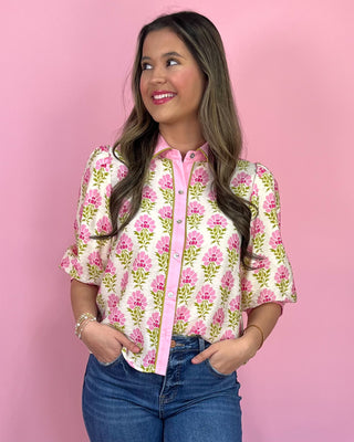 Woman wearing a floral blouse with a pink background